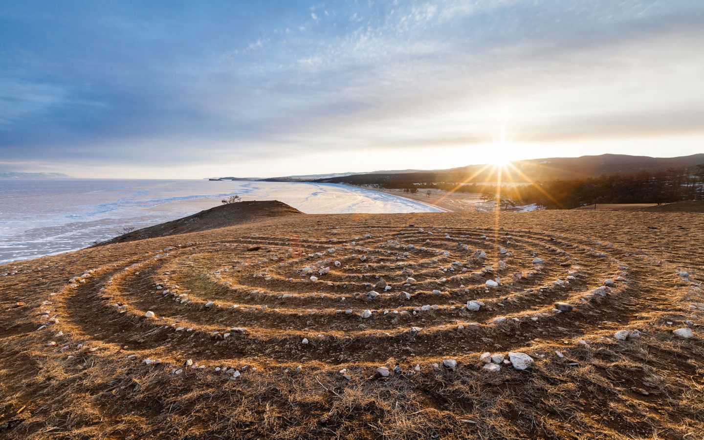 a landscape photo of the sun rising over a shore